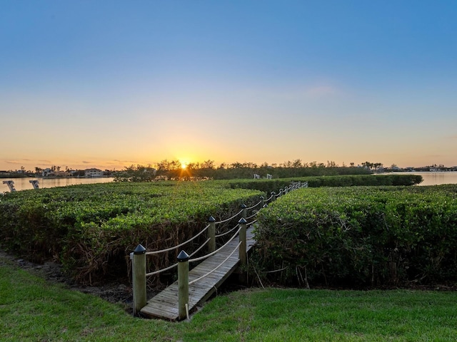 yard at dusk featuring a water view