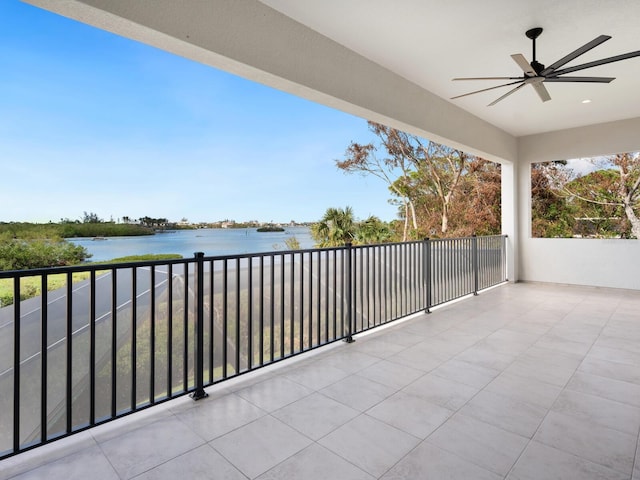 balcony with ceiling fan and a water view