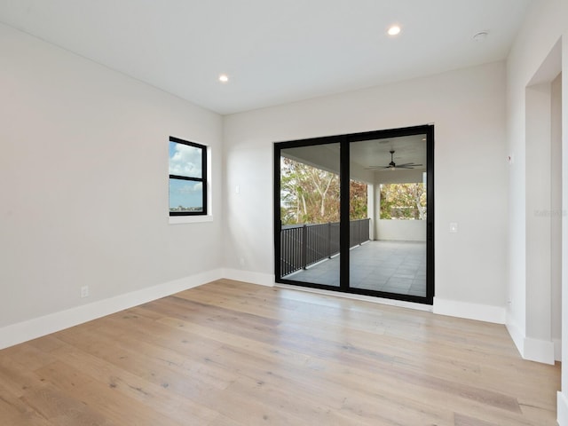 spare room with ceiling fan and light wood-type flooring