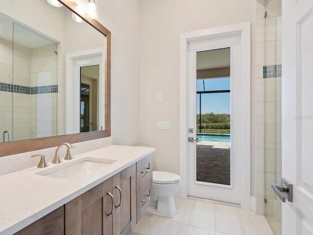 bathroom with tile patterned flooring, vanity, a shower with shower door, and toilet