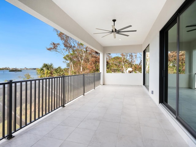 balcony with a water view and ceiling fan