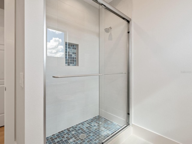 bathroom with a shower with door