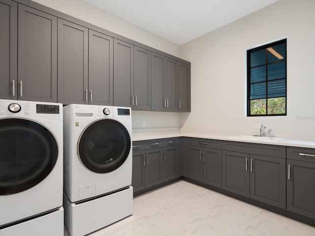 washroom featuring cabinets, separate washer and dryer, and sink