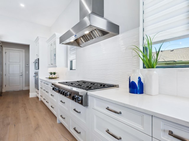 1109 Bayshore Rd, Nokomis, FL 34275 - kitchen featuring stainless steel appliances, island exhaust hood, decorative backsplash, white cabinetry, and glass insert cabinets