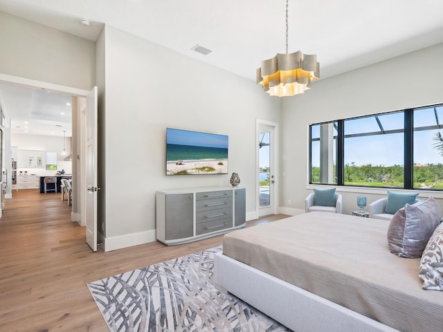 1109 Bayshore Rd, Nokomis, FL 34275 - bedroom with access to outside, baseboards, a chandelier, and light wood-type flooring