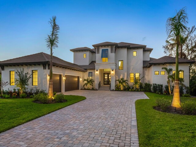 1109 Bayshore Rd, Nokomis, FL 34275 - view of front of property with french doors, decorative driveway, stucco siding, a garage, and a front lawn