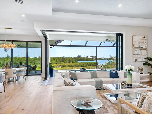 1109 Bayshore Rd, Nokomis, FL 34275 - living room with recessed lighting, light wood-type flooring, a ceiling fan, a water view, and a sunroom