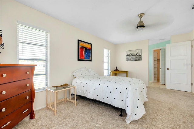 bedroom featuring ceiling fan, a closet, and light colored carpet