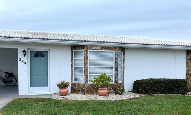 entrance to property featuring a yard