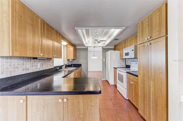 kitchen featuring white appliances, sink, backsplash, a tray ceiling, and tile patterned flooring