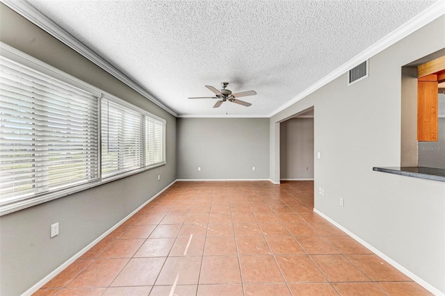 tiled spare room with crown molding, a textured ceiling, and ceiling fan