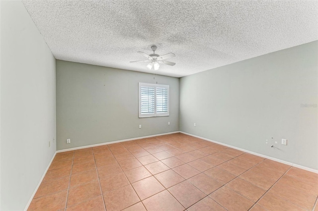 tiled spare room with a textured ceiling and ceiling fan