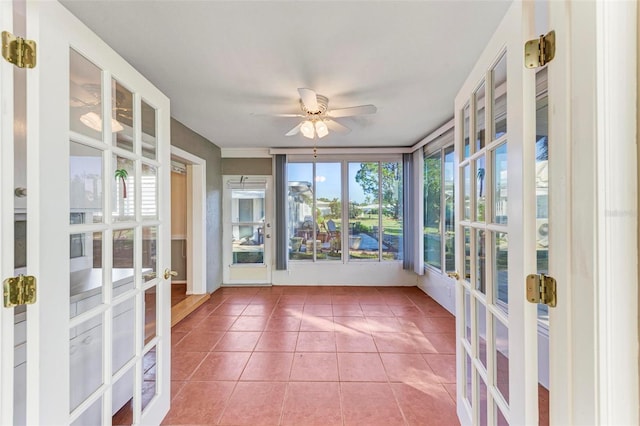 unfurnished sunroom with ceiling fan