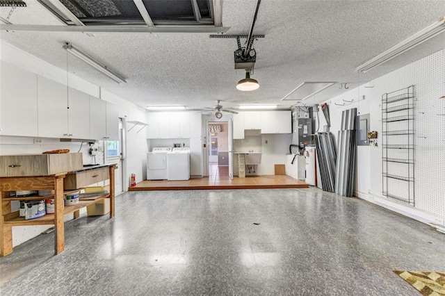 garage with sink, a garage door opener, washer and clothes dryer, and ceiling fan