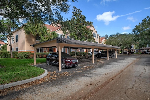 view of car parking with a carport and a lawn