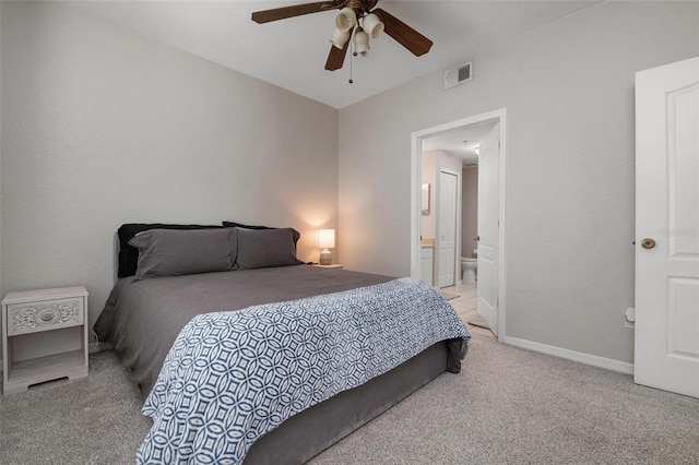 carpeted bedroom featuring ensuite bath and ceiling fan