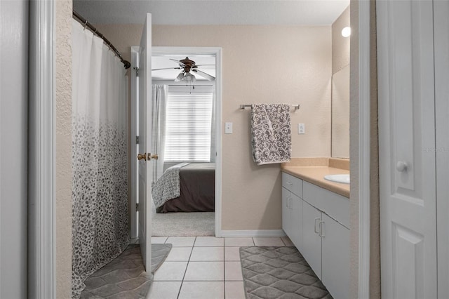 bathroom with a textured ceiling, a shower with shower curtain, ceiling fan, tile patterned floors, and vanity