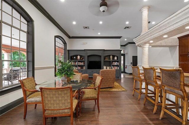 dining space featuring decorative columns, ornamental molding, and dark hardwood / wood-style floors