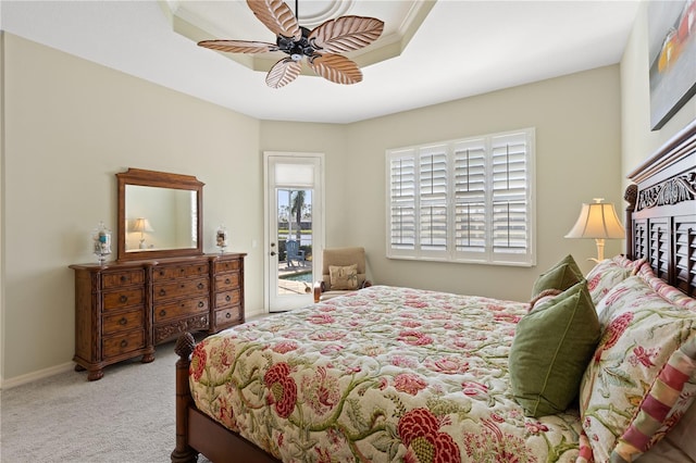 bedroom with access to outside, a tray ceiling, light carpet, and ceiling fan