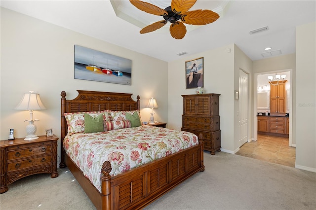 carpeted bedroom featuring ceiling fan and ensuite bath