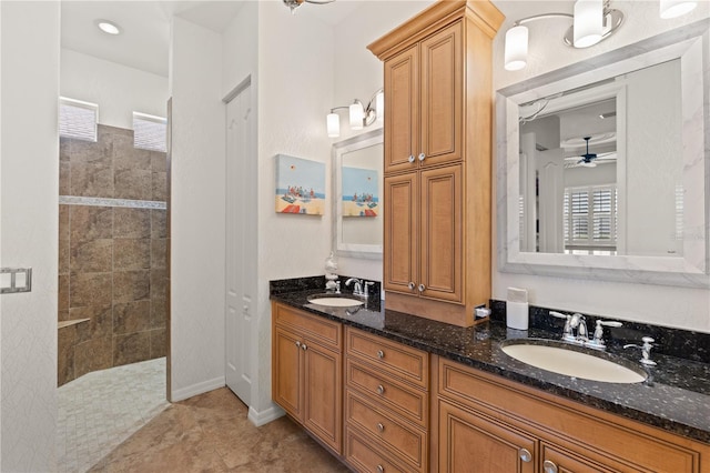 bathroom featuring ceiling fan, vanity, tile patterned floors, and a tile shower