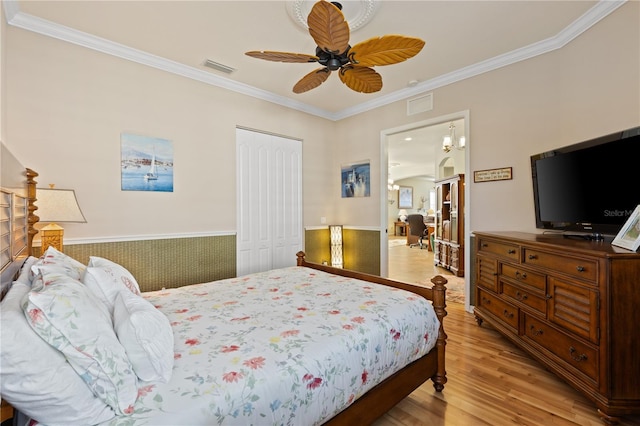 bedroom featuring a closet, light hardwood / wood-style floors, ceiling fan, and crown molding