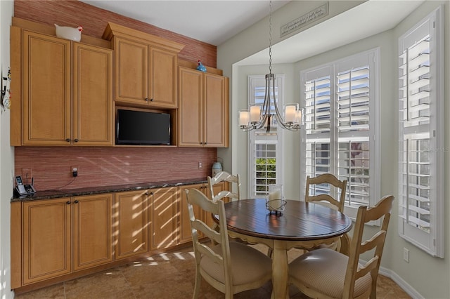 dining room featuring baseboards, tile patterned floors, and an inviting chandelier