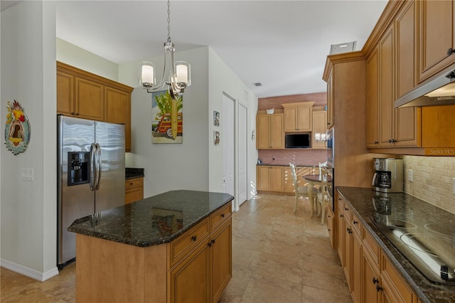 kitchen with stainless steel appliances, hanging light fixtures, backsplash, a kitchen island, and dark stone counters