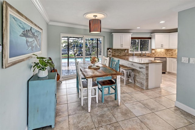 tiled dining area with crown molding and sink