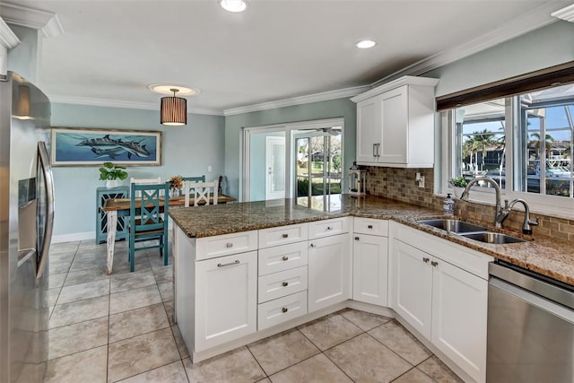 kitchen featuring backsplash, white cabinets, sink, ornamental molding, and stainless steel appliances