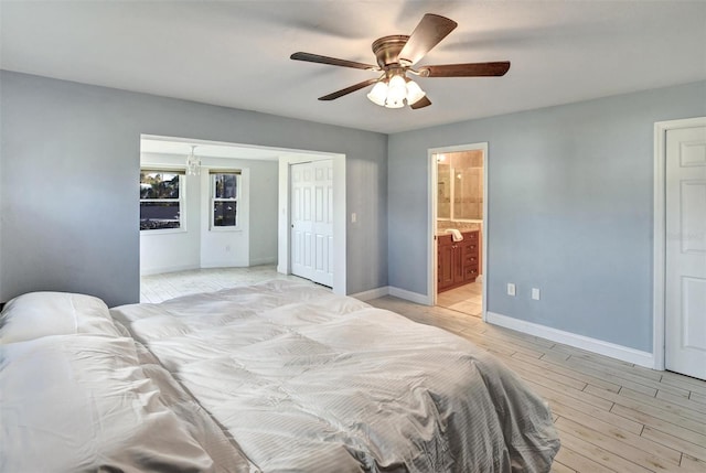 bedroom featuring a closet, light wood-type flooring, ensuite bathroom, and ceiling fan