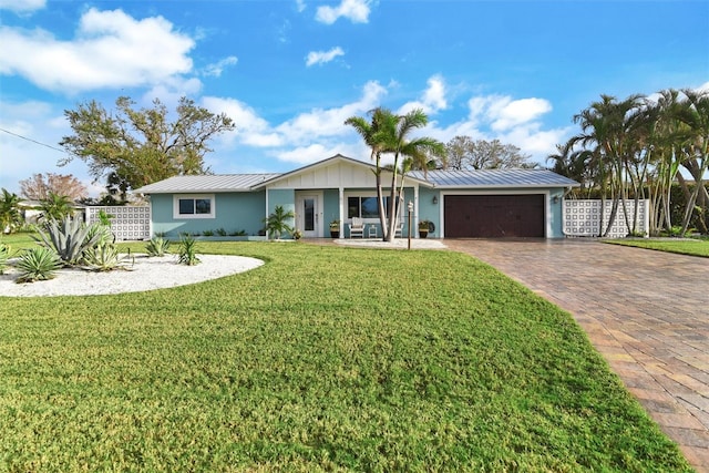 single story home featuring covered porch, a front yard, and a garage