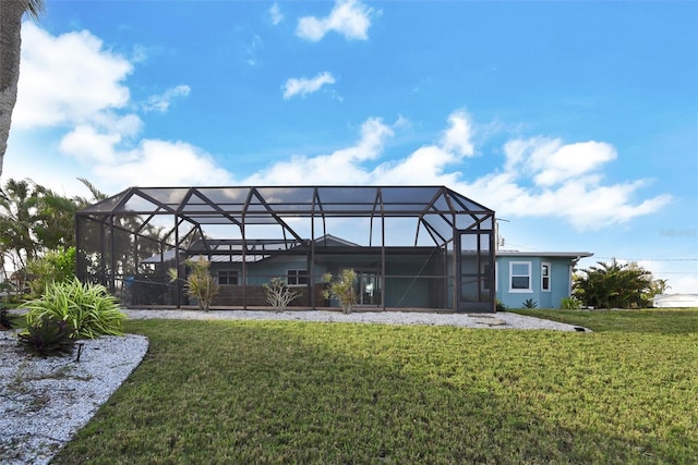 rear view of property featuring a yard and glass enclosure