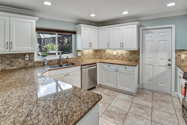 kitchen featuring appliances with stainless steel finishes, tasteful backsplash, white cabinetry, and sink