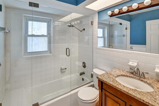 full bathroom with decorative backsplash, vanity, tile walls, enclosed tub / shower combo, and toilet