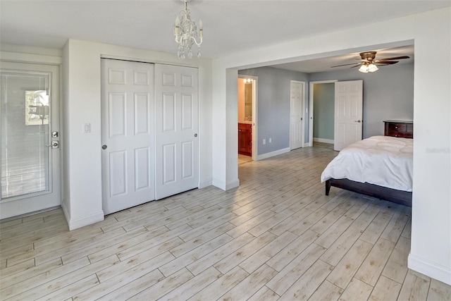 bedroom with ceiling fan with notable chandelier, light hardwood / wood-style floors, and multiple windows