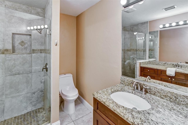 bathroom featuring tile patterned flooring, vanity, toilet, and a shower with shower door