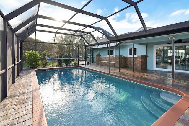 view of pool with a patio, glass enclosure, and ceiling fan