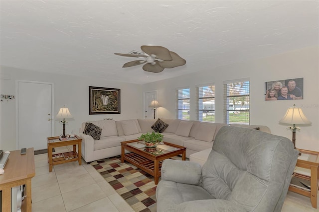 tiled living room with ceiling fan and a textured ceiling