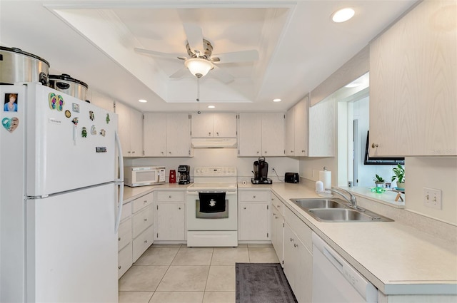 kitchen with ceiling fan, light tile patterned floors, a raised ceiling, sink, and white appliances