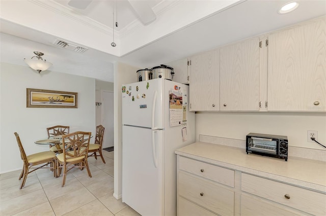 kitchen with white fridge, crown molding, light tile patterned flooring, and ceiling fan