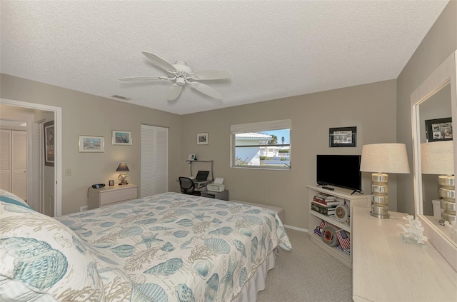 carpeted bedroom with a textured ceiling and ceiling fan