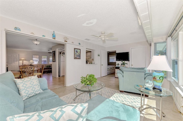 tiled living room featuring a textured ceiling and ceiling fan