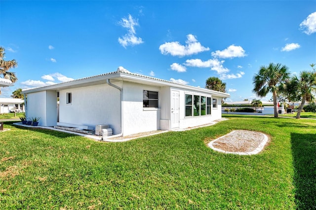 back of property featuring a lawn