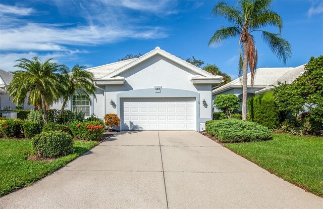 ranch-style house featuring a garage and a front lawn