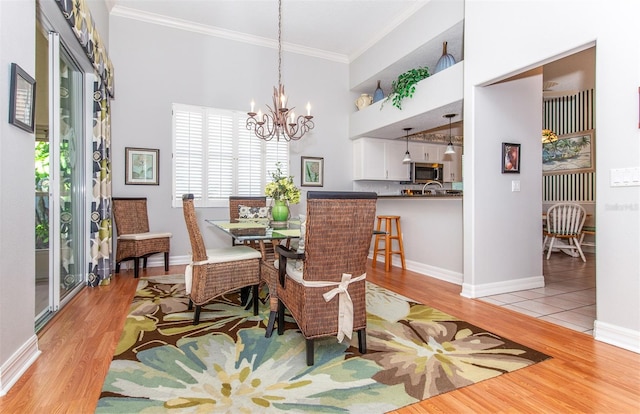 649 Crossfield Cir Unit 10, Venice, FL 34293 - dining area featuring light wood finished floors, a chandelier, ornamental molding, and baseboards