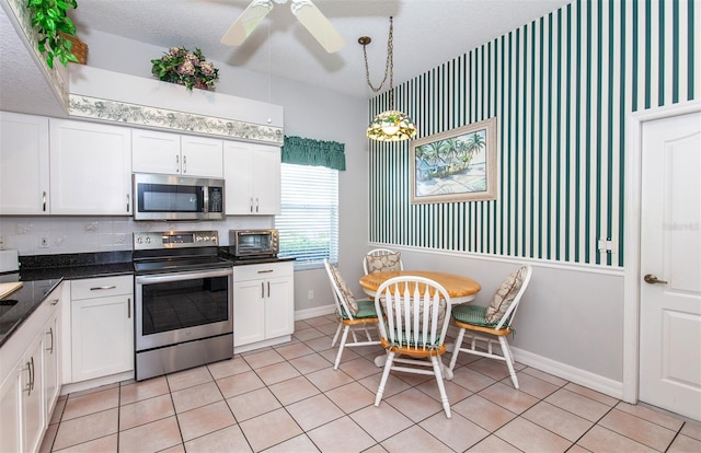 649 Crossfield Cir Unit 10, Venice, FL 34293 - kitchen featuring appliances with stainless steel finishes, baseboards, a ceiling fan, white cabinetry, and dark countertops