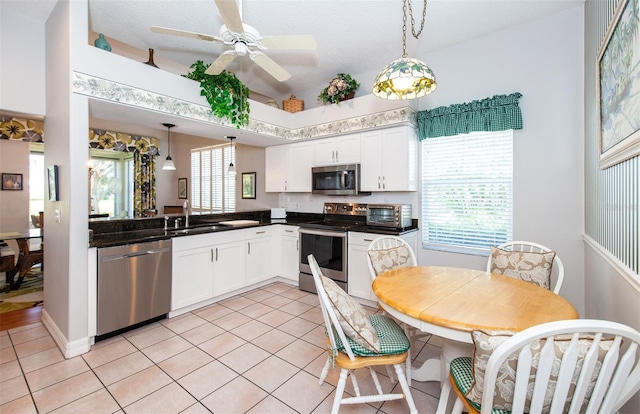 649 Crossfield Cir Unit 10, Venice, FL 34293 - kitchen featuring appliances with stainless steel finishes, a sink, dark countertops, white cabinets, and lofted ceiling