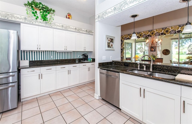 649 Crossfield Cir Unit 10, Venice, FL 34293 - kitchen with appliances with stainless steel finishes, a sink, white cabinets, and decorative light fixtures