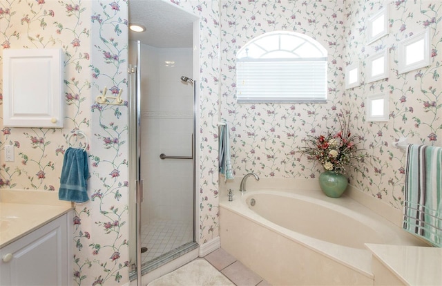 649 Crossfield Cir Unit 10, Venice, FL 34293 - bathroom with wallpapered walls, vanity, a shower stall, a garden tub, and tile patterned flooring
